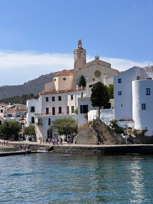 Scenic view of a historic church and charming buildings along a coastal town.